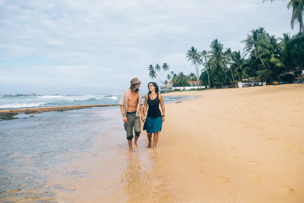 Couple walking on sandy shore Beaches in Sri Lanka