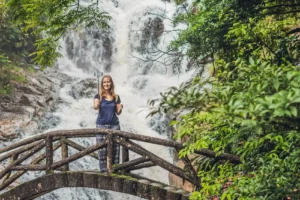 excited female tourist making self portrait front waterfall